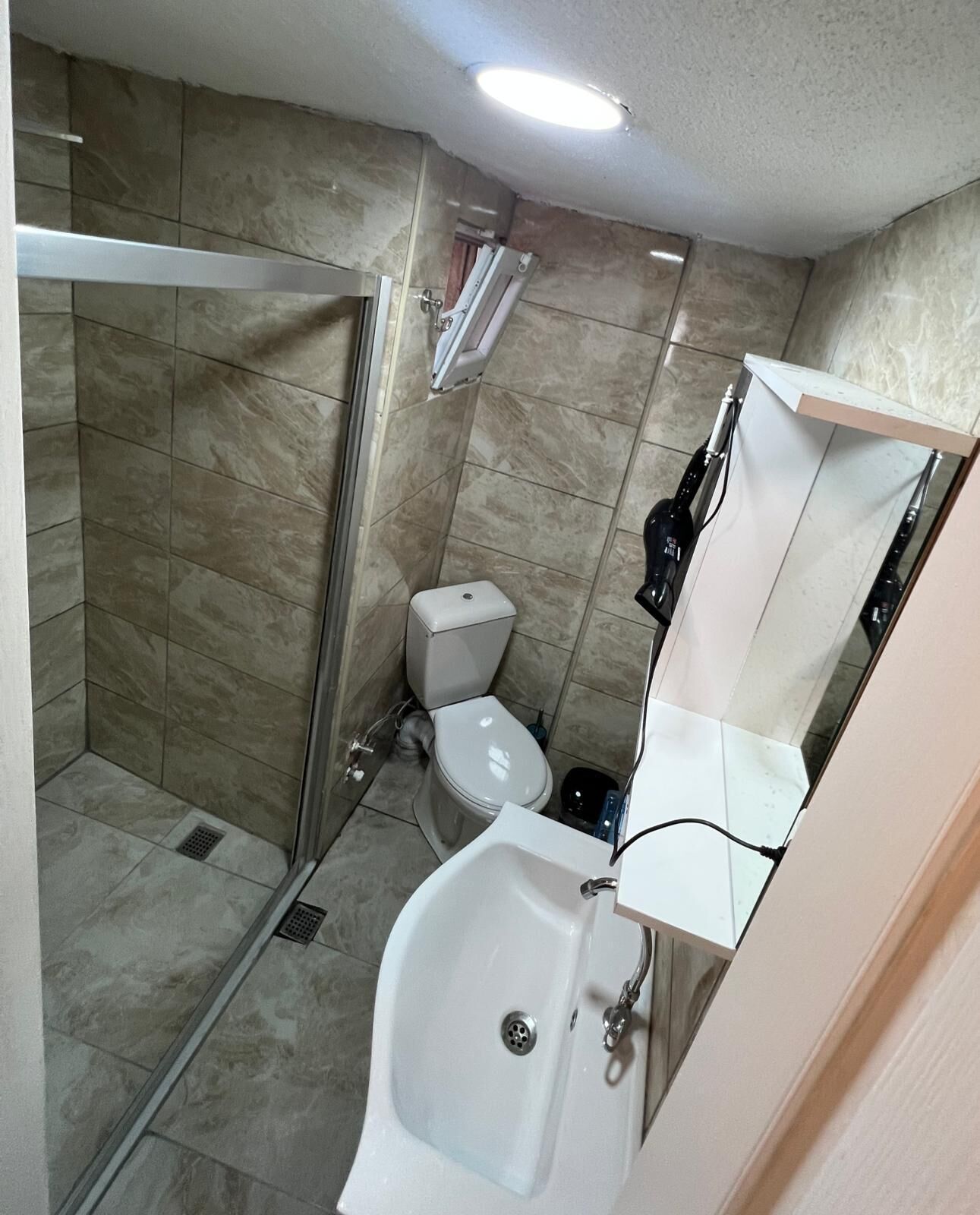 A bathroom with a shower, toilet, and sink.