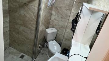 A bathroom with a shower, toilet, and sink.