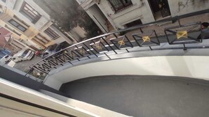 Un escalier en colimaçon avec des rampes en métal et des décorations en forme d’étoile.