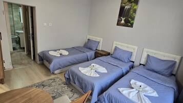 Habitación triple Deluxe, balcón | Zona de estar