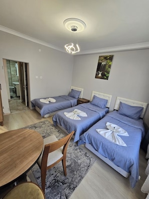 Habitación triple Deluxe, balcón | Zona de estar