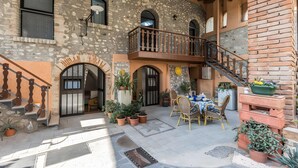 A courtyard with a staircase, outdoor seating, and potted plants. - Apartment 'Luna' with Shared Terrace, Wi-Fi and Air Conditioning (San Felice del Benaco)