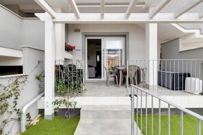 A residential property with a covered patio, outdoor seating, and a visible entrance to the house. - Patio, air conditioning and communal pool (Castelsardo)