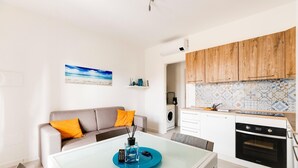 Eine moderne Küche mit Holzschränken, einem eingebauten Ofen und einer gefliesten Spritzschutzwand.