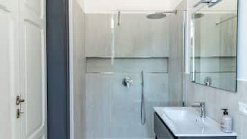 Departamento estándar, vista al jardín | Baño | Regadera, toallas, jabón, shampoo
