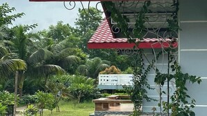 A building with a red tiled roof, a wooden deck, and a stone wall. - Hotel Rowshon Int Jamalpur (Jamalpur)