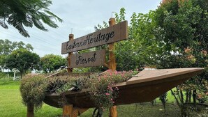 A wooden sign with 'Eastern Heritage Resort' written on it, supported by a wooden structure with hanging flower baskets. - Hotel Rowshon Int Jamalpur (Jamalpur)