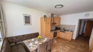 A compact kitchen with a dining table set for two, a sofa, and a small cabinet. - Stylish mountain apartment with terrace in Flattach near Mölltal Glacier (Flattach)