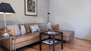 A living room with a sofa, a coffee table, a lamp, and a framed picture on the wall. - Small house | city location | seeglueck (Konstanz)