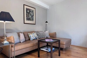 Ein Wohnzimmer mit einer Couch, einem Couchtisch, einer Lampe und einem gerahmten Bild an der Wand.