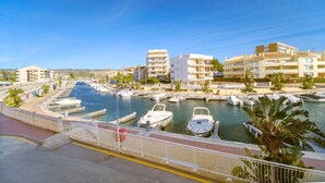 A marina with boats docked, surrounded by buildings and palm trees. - Venecia Beach Apartment Javea Arenal (Javea / Xàbia)
