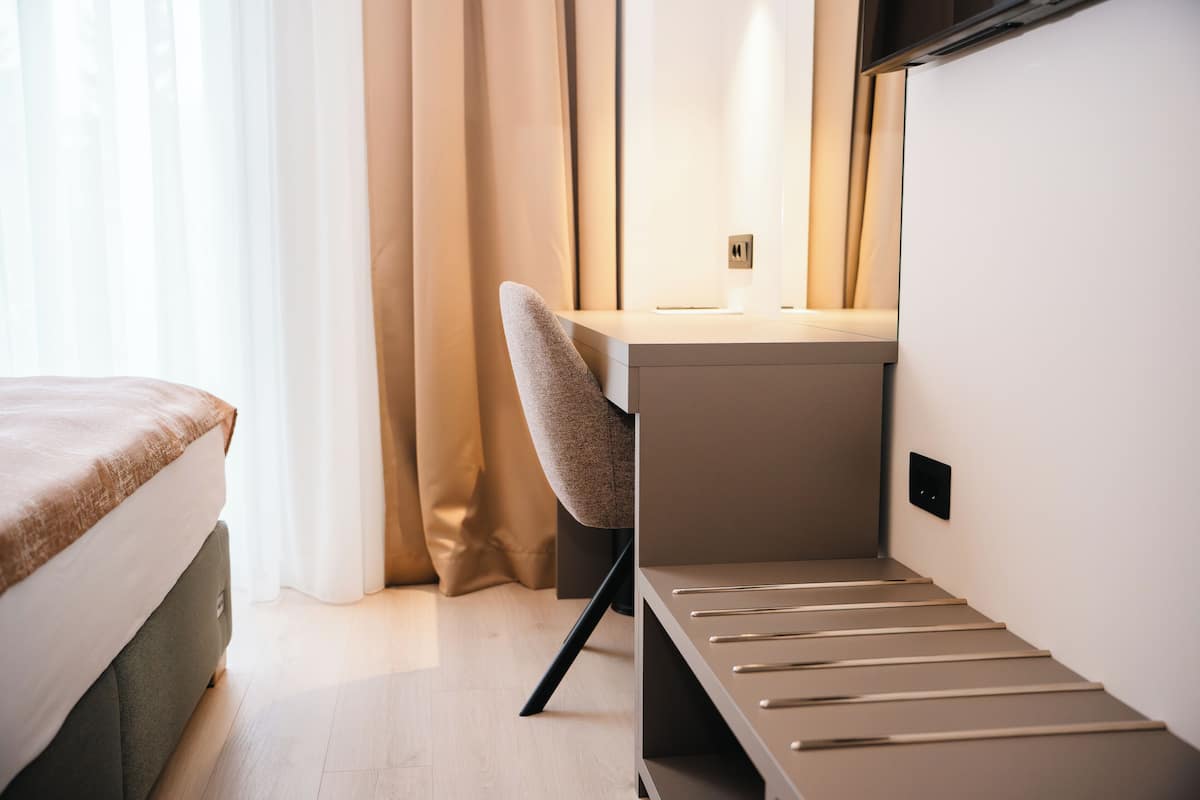 Una habitación pequeña con cama, escritorio y silla.