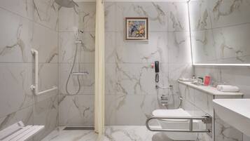 Een moderne badkamer met douche, toilet en wastafel.