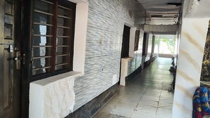 A corridor with a tiled floor, a door with a metal grill, and a patterned wall. - Babalao Hotel & Restaurant Malindi (Malindi)