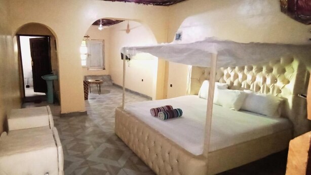 A room with a bed, a small table, and a sink. - Babalao Hotel & Restaurant Malindi (Malindi)