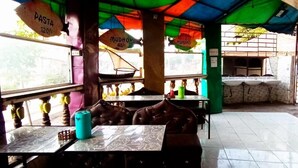 A restaurant with tables and booths, a tiled floor, and hanging signs indicating menu items. - Babalao Hotel & Restaurant Malindi (Malindi)