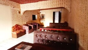 A room with patterned wallpaper, a sofa, a cushioned bench, and a table. - Babalao Hotel & Restaurant Malindi (Malindi)