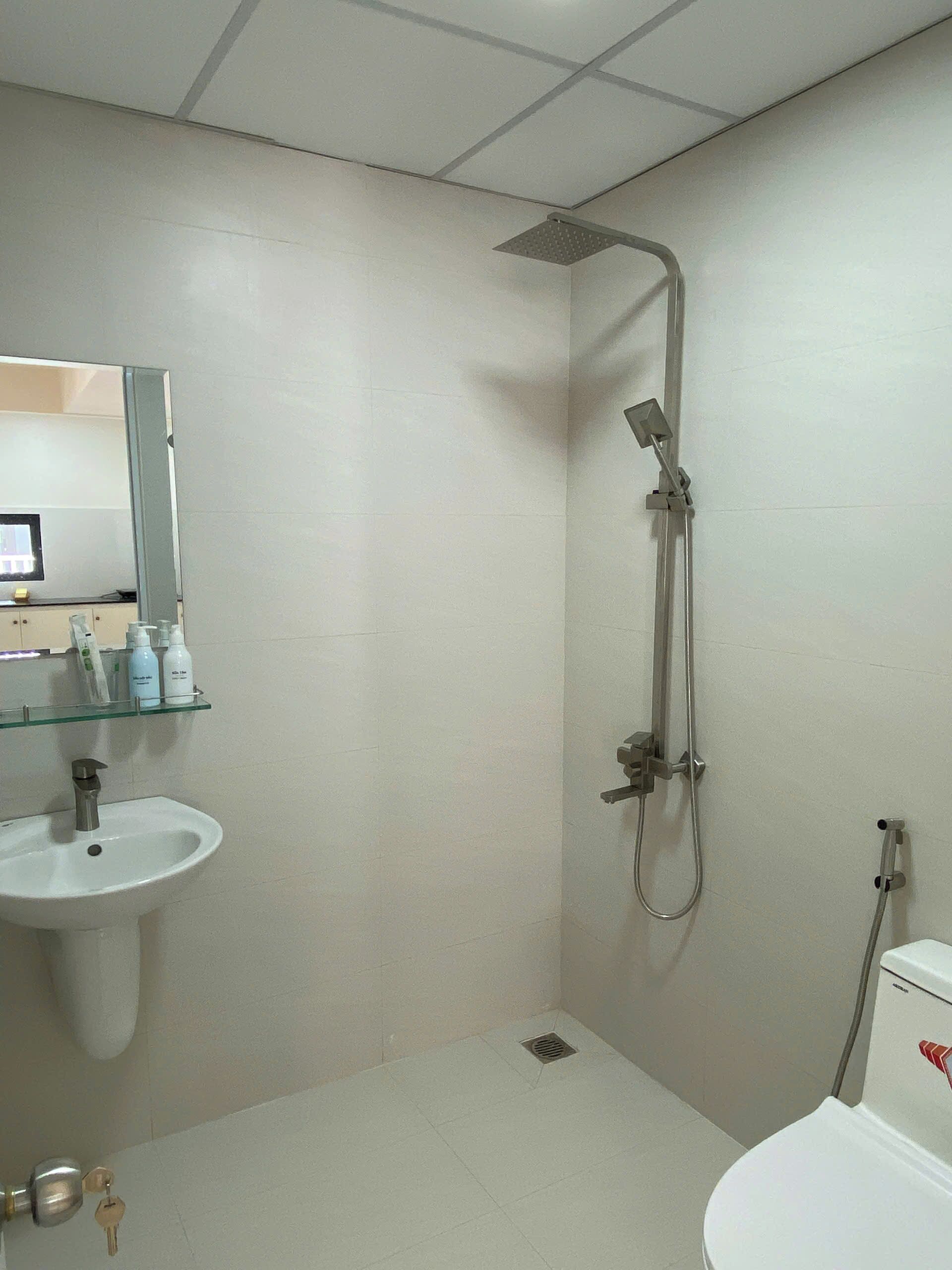 A bathroom with a shower, sink, and toilet.
