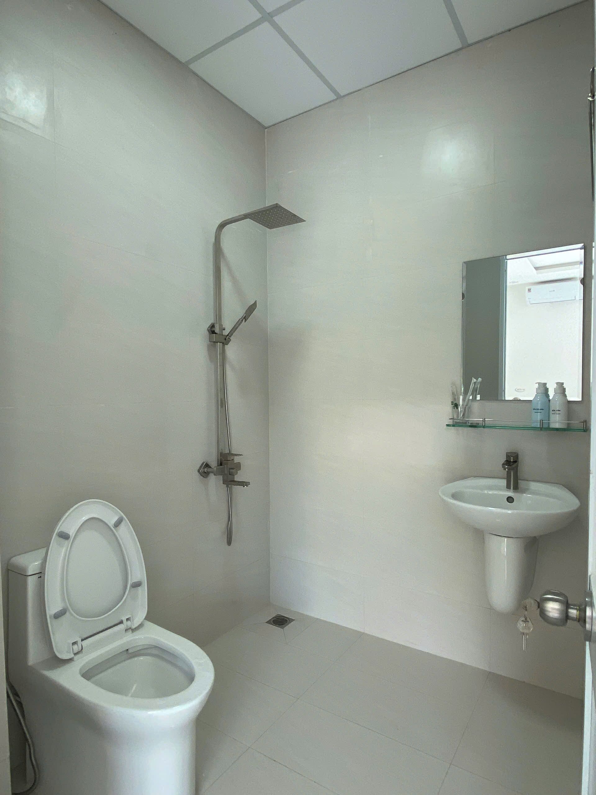 Un baño con inodoro, ducha y lavamanos.