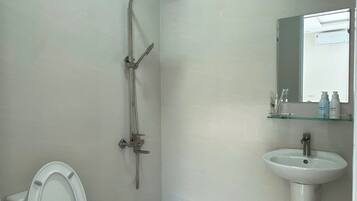 Un baño con inodoro, ducha y lavamanos.