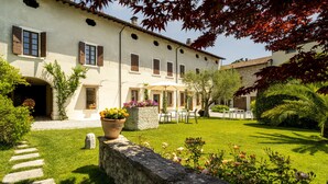 Un edificio con giardino, muro in pietra e area salotto all'aperto.