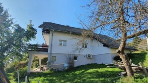 Une maison à deux étages, dotée d’un toit en pente, d’un porche abrité et d’une pelouse bien entretenue.