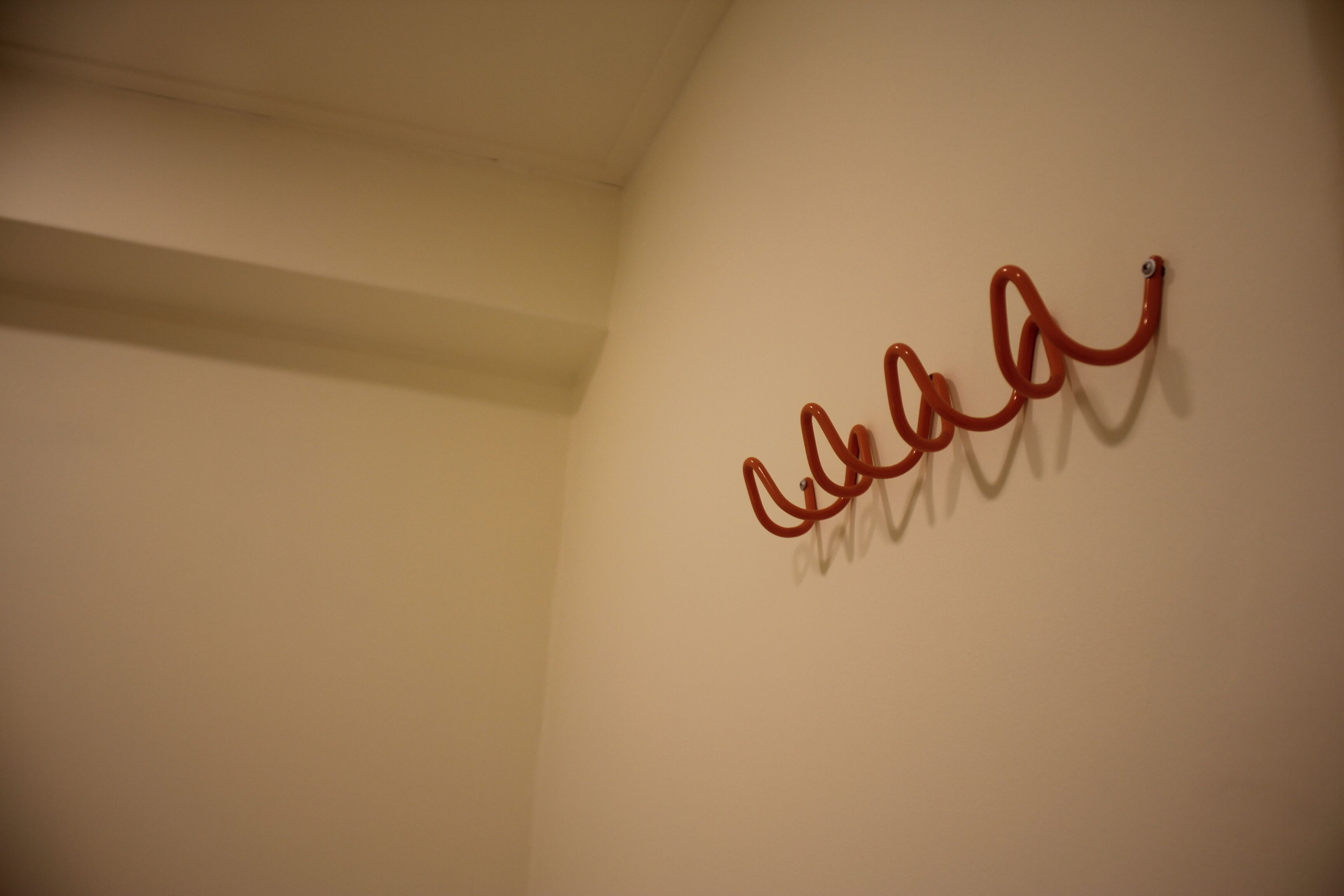 A wall with a red, abstract, looping design.