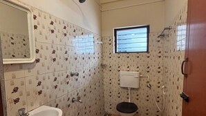 Un baño pequeño con lavamanos, inodoro y ducha.