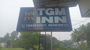 Señalización de TGM Inn con números de contacto y detalles de ubicación.