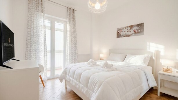 Ein Hotelzimmer mit Bett, Schreibtisch, Fernseher und einem Fenster mit Vorhängen.