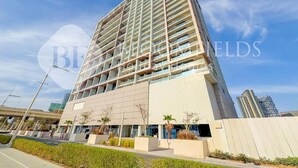 Un moderno edificio de gran altura con múltiples balcones, ventanas amplias y un diseño limpio y contemporáneo.