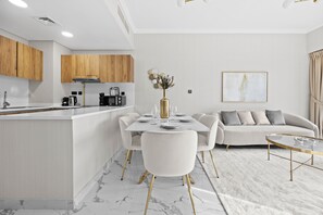 Eine moderne Küche mit Holdekor, einer zentralen Kochinsel und einem Essbereich mit weißem Tisch und Stühlen.