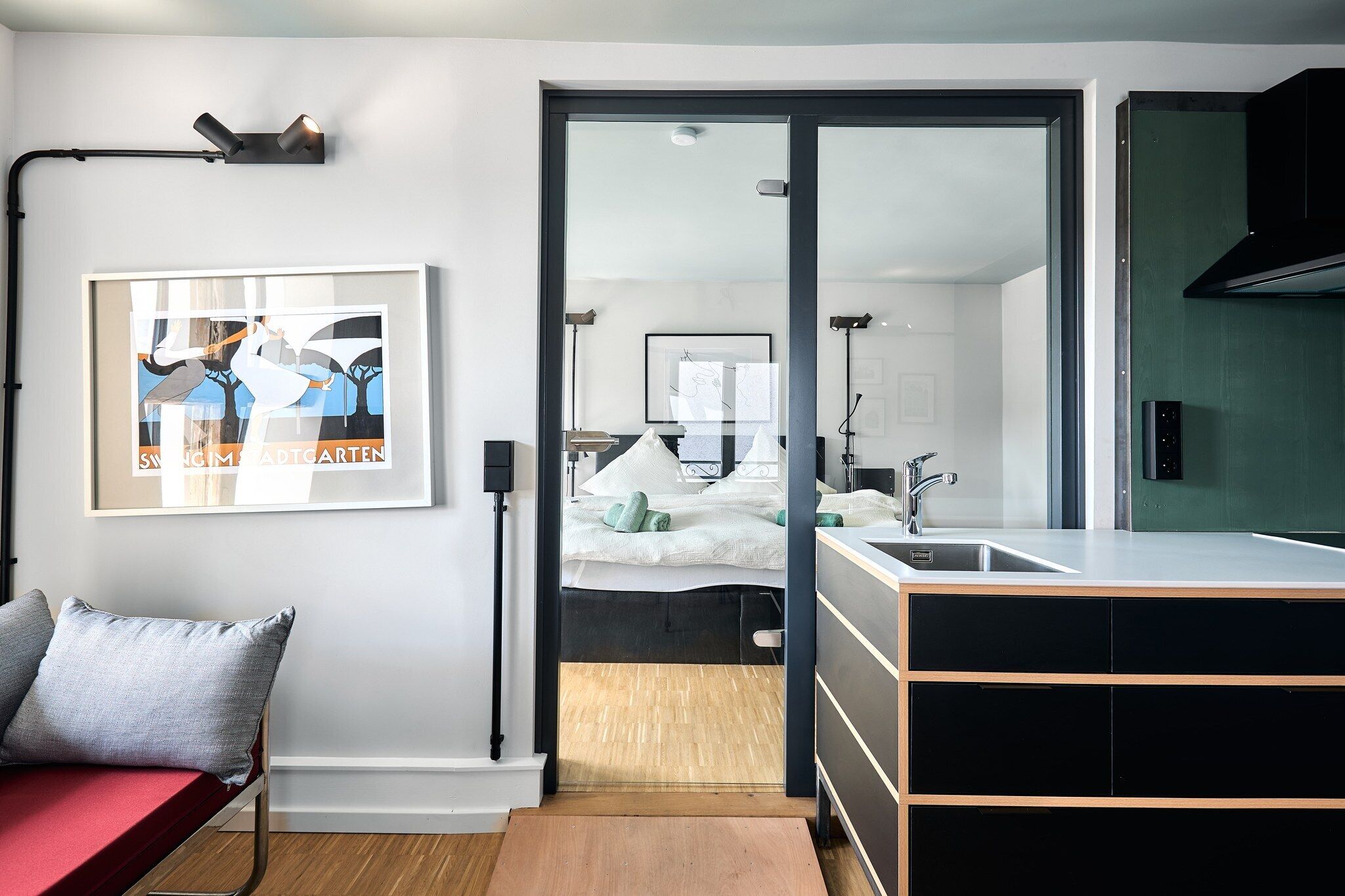 A modern bedroom with a bed, bedside table, and a framed picture on the wall.