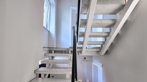Un escalier en béton avec une rampe et une porte en bas.
