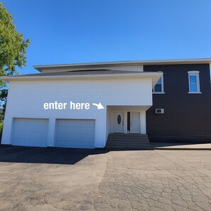 A modern two-story house with a garage door labeled "enter here" and a staircase leading to the entrance.