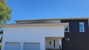 Et toetagers hus med hvid garage og mørkebrun facade.