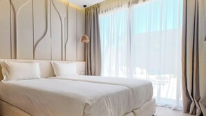 Ein Schlafzimmer mit zwei Betten, einem großen Fenster mit durchsichtigen Vorhängen und einer Wand mit modernem Design.