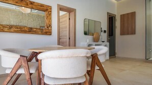 Ein moderner Essbereich mit einem Holztisch und -stühlen, einem großen Spiegel und einer Wand mit Steinoptik.