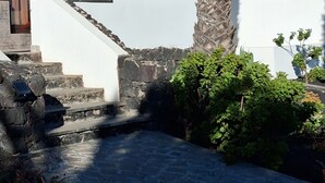Una scala in pietra conduce a un edificio bianco con un balcone in legno.