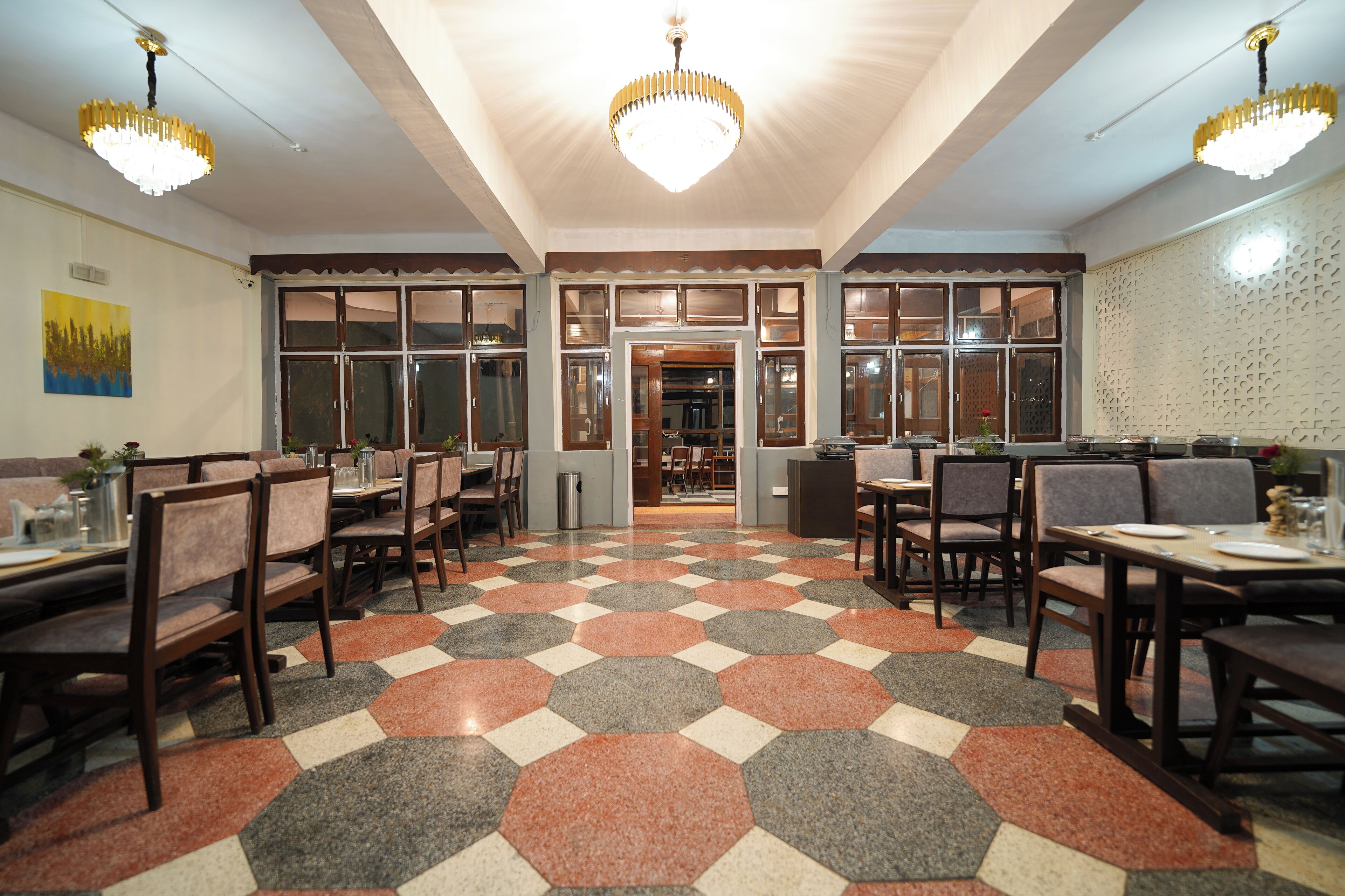 Un restaurant doté d’un sol à motifs hexagonaux, de meubles en bois et de lustres.