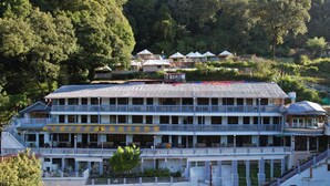 A multi-story hotel with balconies, a swimming pool, and a view of the surrounding forest. -  Hotel Silverton (180 lake view)  (Nainital)