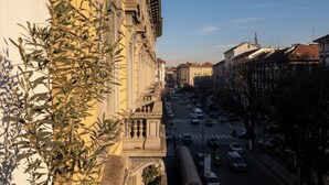 Vista callejera con edificios, cielo despejado y una carretera con automóviles.