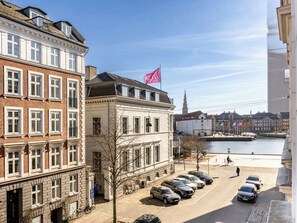 A row of parked cars along a waterfront street with historic buildings and a flag on top. - Shield 2 - Great Apartment in the Centre of Copenhagen (Copenhagen)