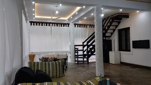 Un espacio habitable amplio con una escalera, una mesa de comedor y un sofá.