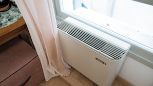 A room with a window, a radiator, a wooden floor, and a pink cabinet. - Cozy room in the heart of city (Verona)