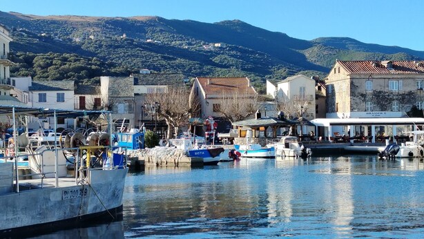A marina with boats docked, a building with a sign 'BRASSER E', and a mountainous backdrop. - Macinaggio Vacation Home, 5 Minutes from the Beach (Rogliano)