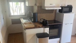 A compact kitchen with a window, a sink, a stove, and a trash bin. - Macinaggio Vacation Home, 5 Minutes from the Beach (Rogliano)