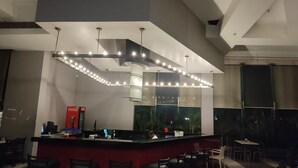 A modern bar area with a counter, seating, and a large window. - EXPRESS FOOD PLAZA (Kolaghat)