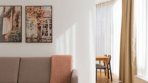 Una sala de estar moderna con un sofá, una mesa redonda y dos cuadros en la pared.
