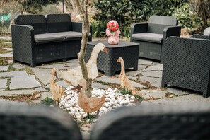 Outdoor wicker furniture, a decorative tree, and a vase with flowers. - HOTEL LOCANDA DELL'OCA BIANCA (Como)